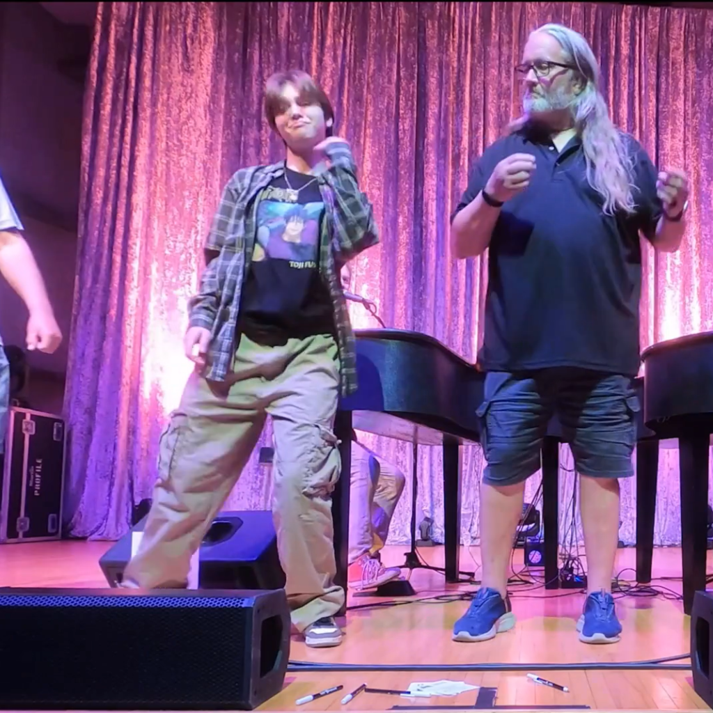 Two audience members dancing onstage during a Midwest Dueling Pianos show.