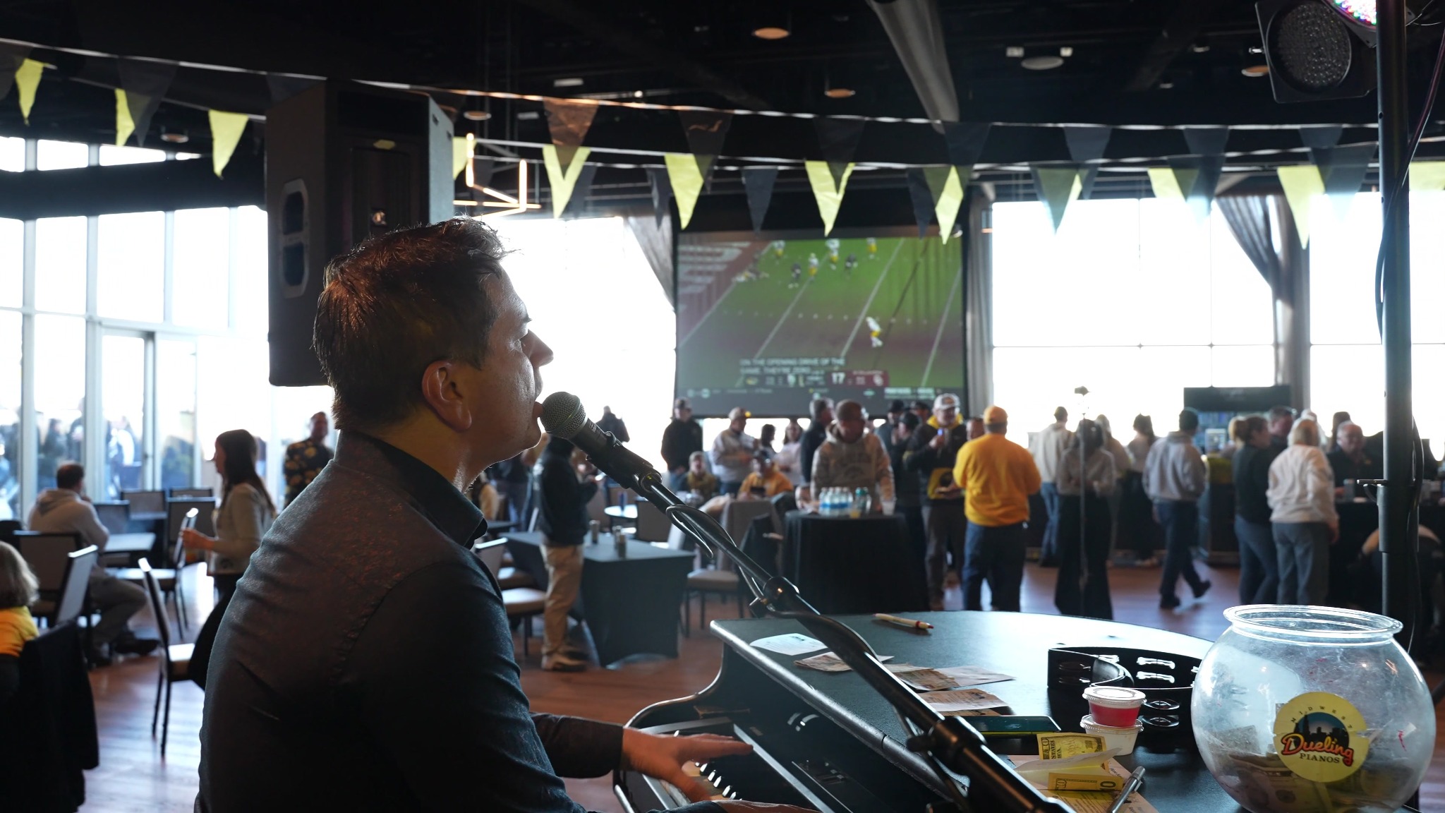 Midwest Dueling Pianos performer singing and playing piano at a college event