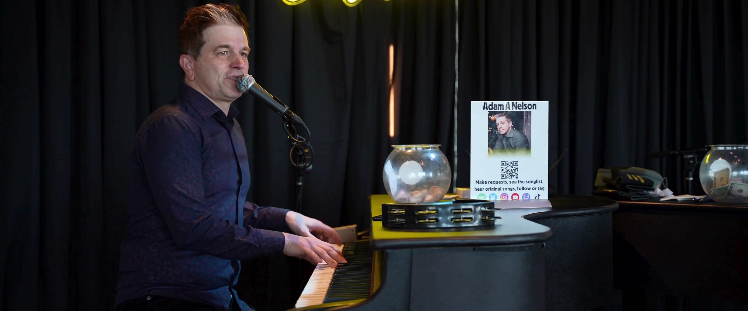 Adam Nelson singing and playing piano during a Midwest Dueling Pianos show.