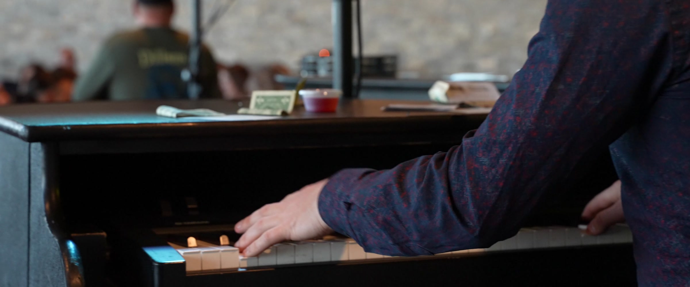 Close-up of a performer playing the piano keys at a Midwest Dueling Pianos show.