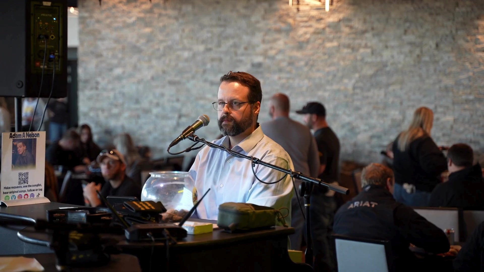 Midwest Dueling Pianos performer singing at a piano with guests seated nearby.