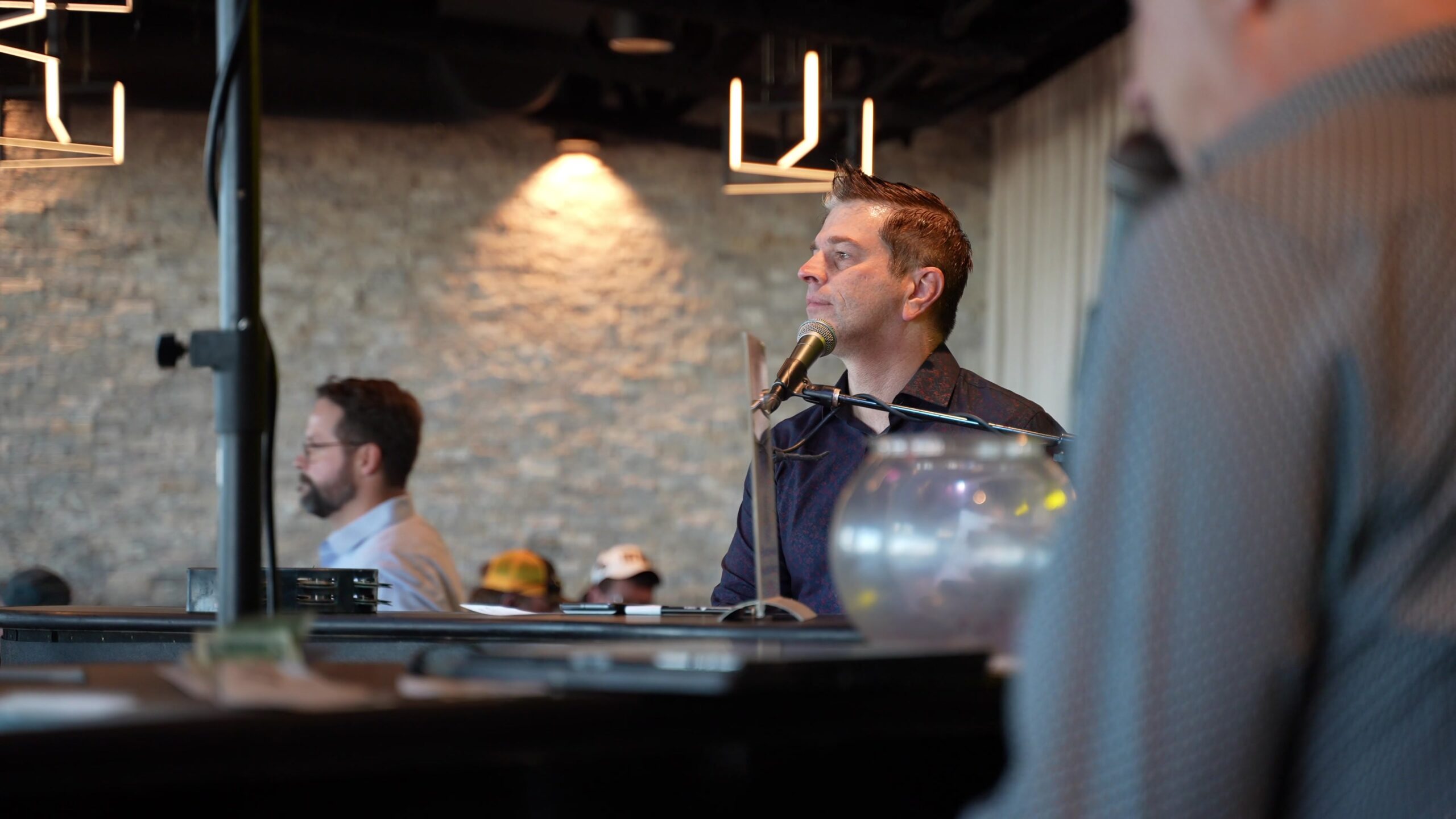Pianist seated at a microphone during a Midwest Dueling Pianos performance.